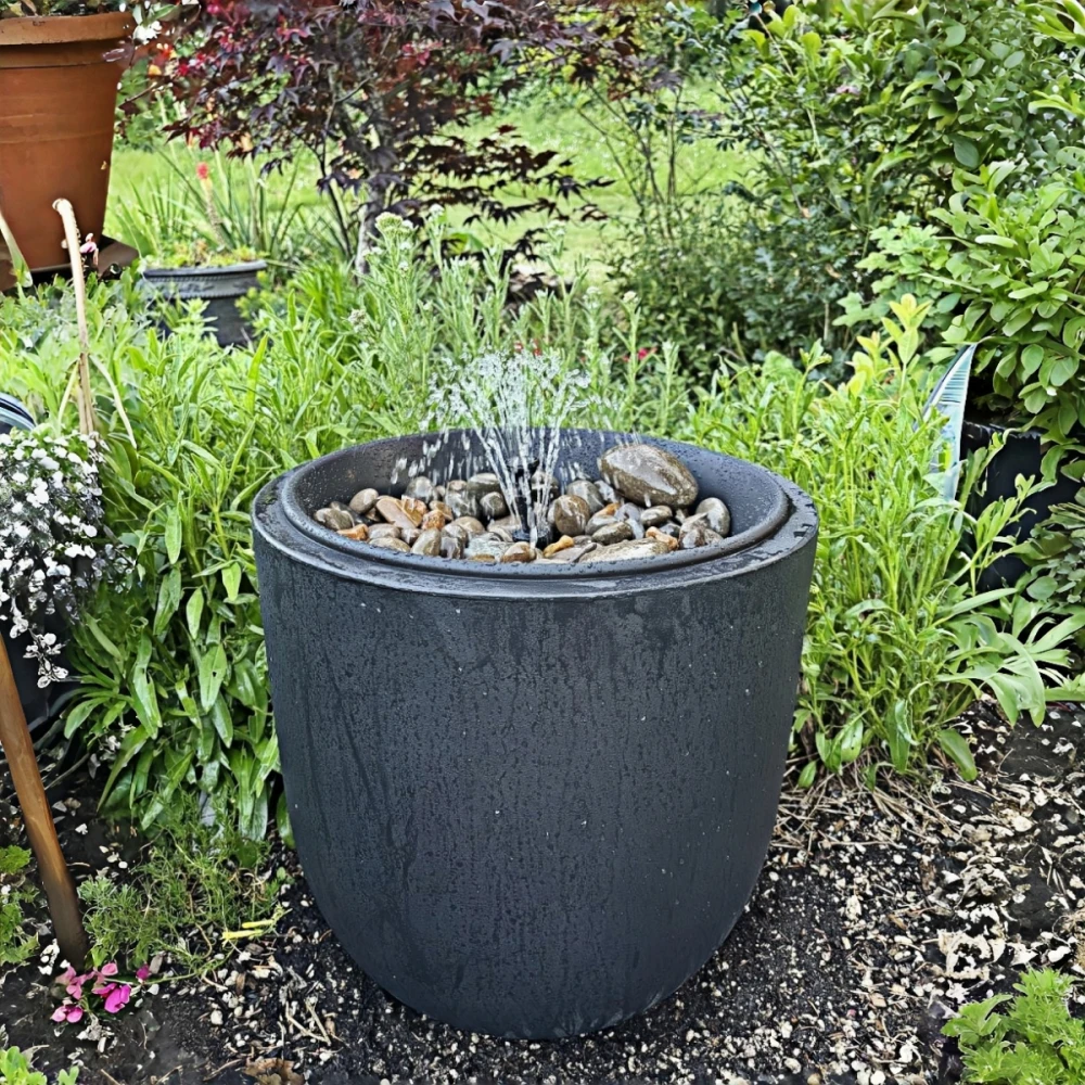 Container fountain in a small garden